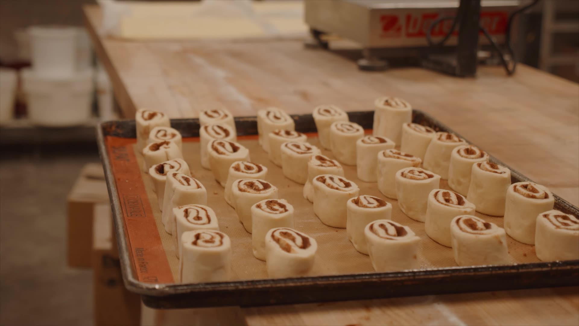 Cinnamon and dark brown sugar spread across fresh Merlen Bakehouse dough